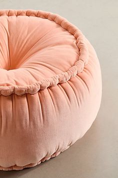 a pink round pillow sitting on top of a table