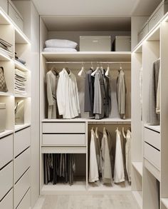 a walk in closet filled with lots of white drawers and clothes on top of shelves