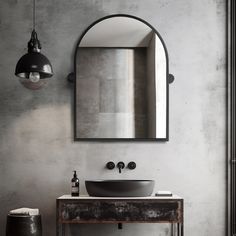 a bathroom sink sitting under a large mirror next to a light hanging from a ceiling