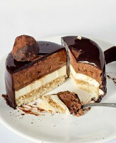 a piece of chocolate cake on a white plate with a bite taken out of it