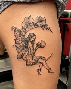 a woman's thigh with a fairy sitting on the moon and flowers around her