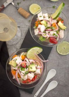 two clear bowls filled with food next to spoons