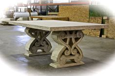 the table is made out of concrete and has an intricate design on it's base