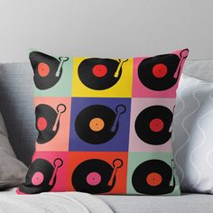 a throw pillow with an image of records on it in different colors and shapes,