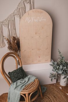 a chair with a blanket on top of it next to a wooden sign and potted plant