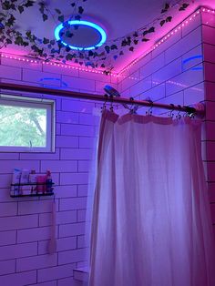 a bathroom with a shower curtain and lights on the ceiling, along with a window