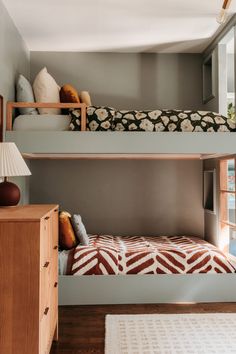 two bunk beds are next to each other in a room with wood floors and white rugs