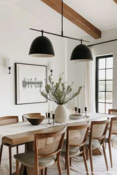 a dining room table with chairs and a vase on it