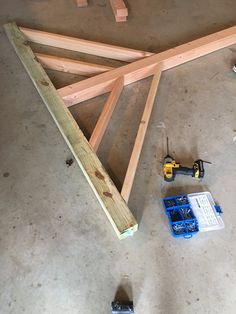 some tools are laying on the floor next to wooden planks