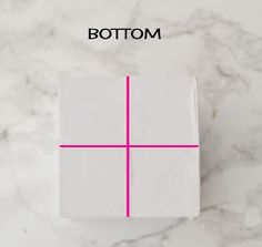 a white box sitting on top of a marble counter next to a pink line that says bottom