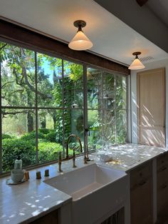 a kitchen with a sink and large windows