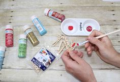 a person is making pops sticks out of toothpicks and glue on a wooden table