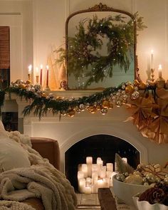 a living room decorated for christmas with candles and wreaths on the fireplace mantel