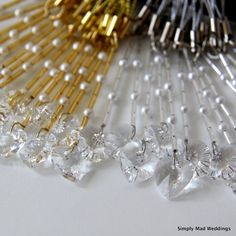 several different types of hair pins on a white surface with gold, silver and crystal beads