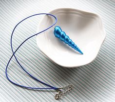 a white bowl with a blue string on it and a metal object in the middle