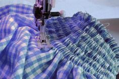 the sewing machine is working on the blue and white checkered fabric that has been sewn