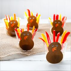 some turkeys are sitting in small cups on a table