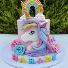 a unicorn cake with flowers and letters on it