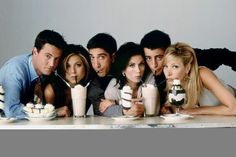 the cast of friends posing for a photo at a table with milkshakes and ice cream