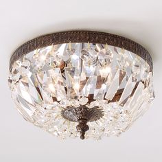 a close up of a ceiling light with crystal beads on the glass and wood frame