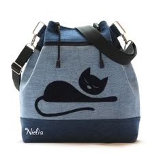 a blue purse with a black cat on it