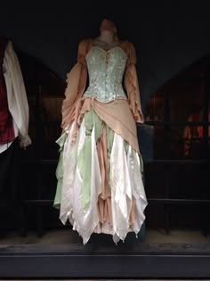 an old fashion dress on display in a window