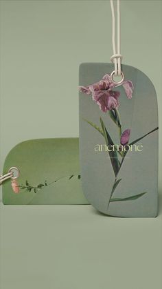 two tags with flowers on them sitting next to each other in front of a green background