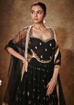 Elevate your style quotient with our Black and Gold Embroidered Lehenga Set. Crafted with exquisite attention to detail, this stunning georgette lehenga features intricate machine-embroidered light gold gota, sequins, and threadwork kalis. With the addition of pockets and cancan for extra volume, it combines elegance with practicality. The hand-embroidered conservative cut blouse dazzles with sequins and cutdana embellishments, while the organza dupatta adds a touch of grace with its tassel bord Sangeet Blouse Designs, Indian Wedding Guest, Indian Bridesmaid Dresses, Cut Blouse, Georgette Lehenga, Indian Outfits Lehenga, Lehenga Designs Simple, Lehenga Blouse Designs, Indian Designer Suits