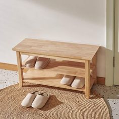 a pair of slippers sitting on top of a rug next to a wooden bench