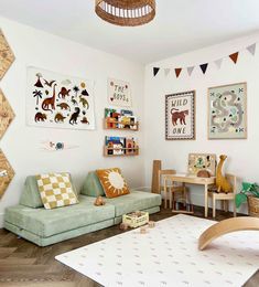 a child's playroom with toys and artwork on the walls, including a green couch