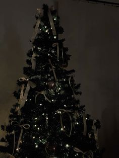 a decorated christmas tree with lights and ribbons