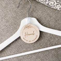 a wooden hanger with the name hannah on it next to a gray and white pillow