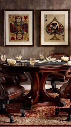 a dining room table with chairs around it and two framed pictures above the table on the wall