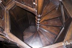 a wooden spiral staircase in an old building