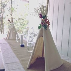 a teepee with flowers in it sitting on a table