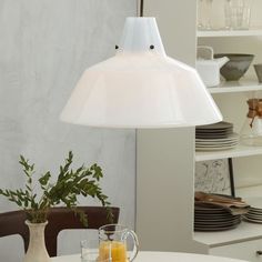 a white lamp hanging over a dining room table