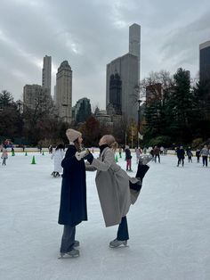 two people standing on an ice rink in the city