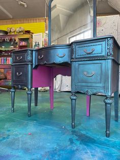 an antique desk with two drawers and a mirror on the floor in front of it