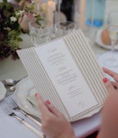 a woman sitting at a table with a menu in her hand