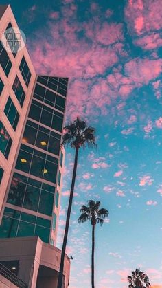 an apple logo is shown on the side of a building with palm trees in front of it