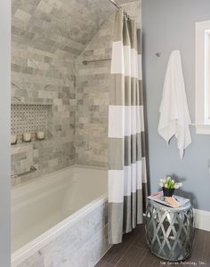 a bath room with a tub a sink and a mirror on the wall next to a window