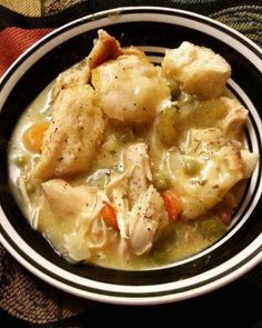 a bowl filled with chicken and dumplings on top of a table