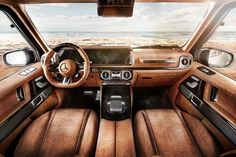 the interior of a mercedes benz car with brown leather seats and steering wheel, looking out onto the beach