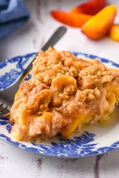 a slice of peach cobbler on a blue and white plate next to sliced peaches