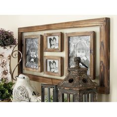 an old wooden frame with three pictures hanging on it's wall next to a lantern and potted plant