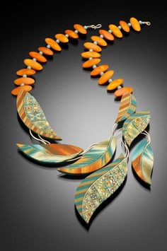 an orange and green necklace on a black background