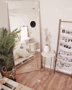 a mirror sitting on top of a wooden floor next to a plant