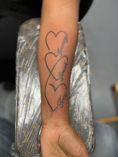 a person with a tattoo on their arm that has three hearts and the words love