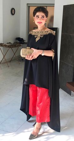 Black velvet cape style top handworked with dabka, tilla and zardozi on the neckline and sleeves. Paired with black flared pants to complete the chic look. (Includes cape and Pants)