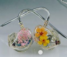 two small glass vases with flowers in them